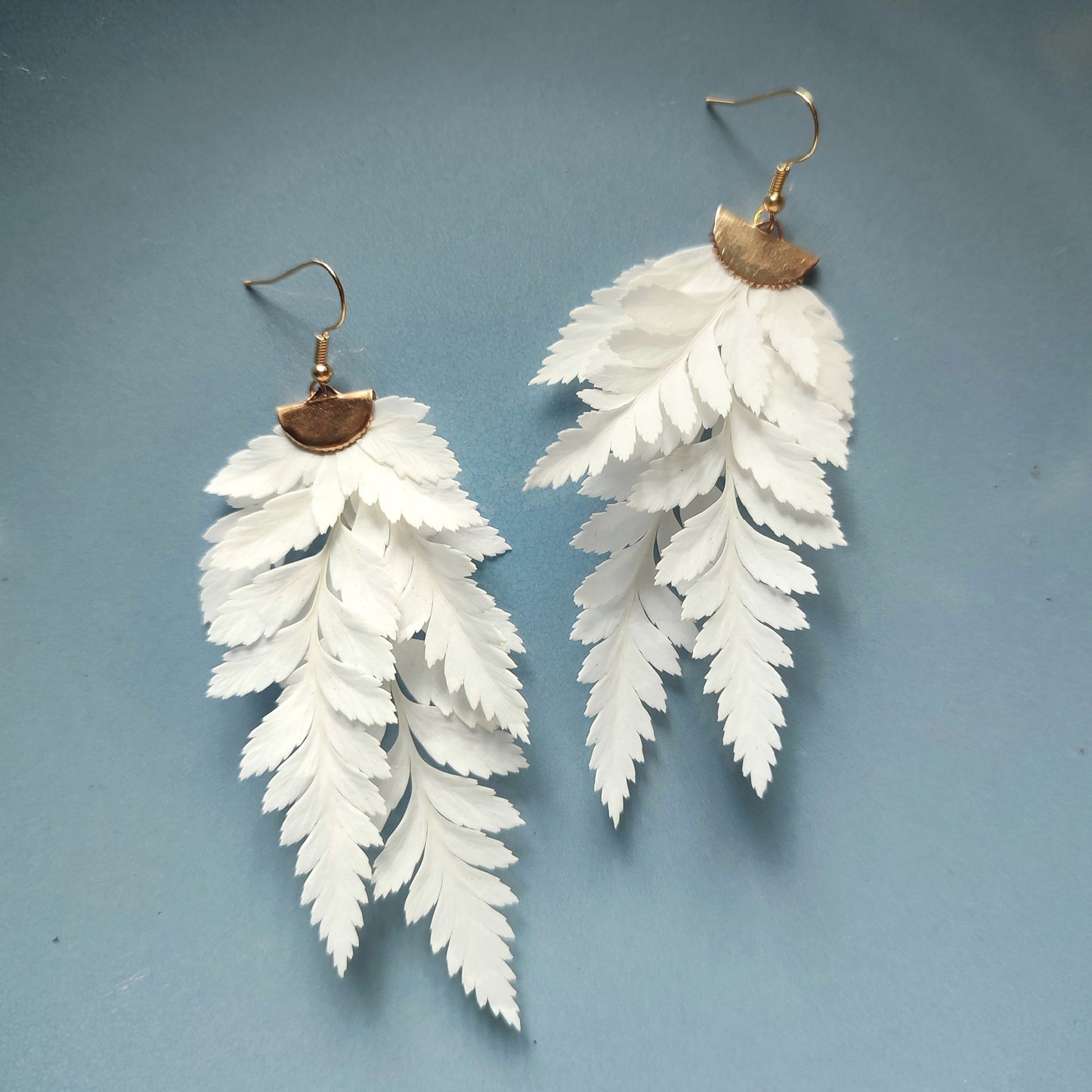 Boucles d'oreilles en fougère stabilisées et séchées, fabriquées à partir de feuilles naturelles, avec des attaches en métal doré.