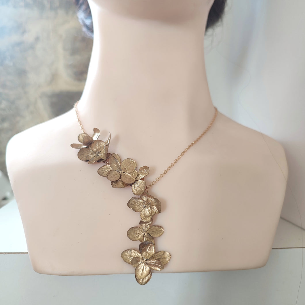 Collier de fleurs d'hortensia dorées.