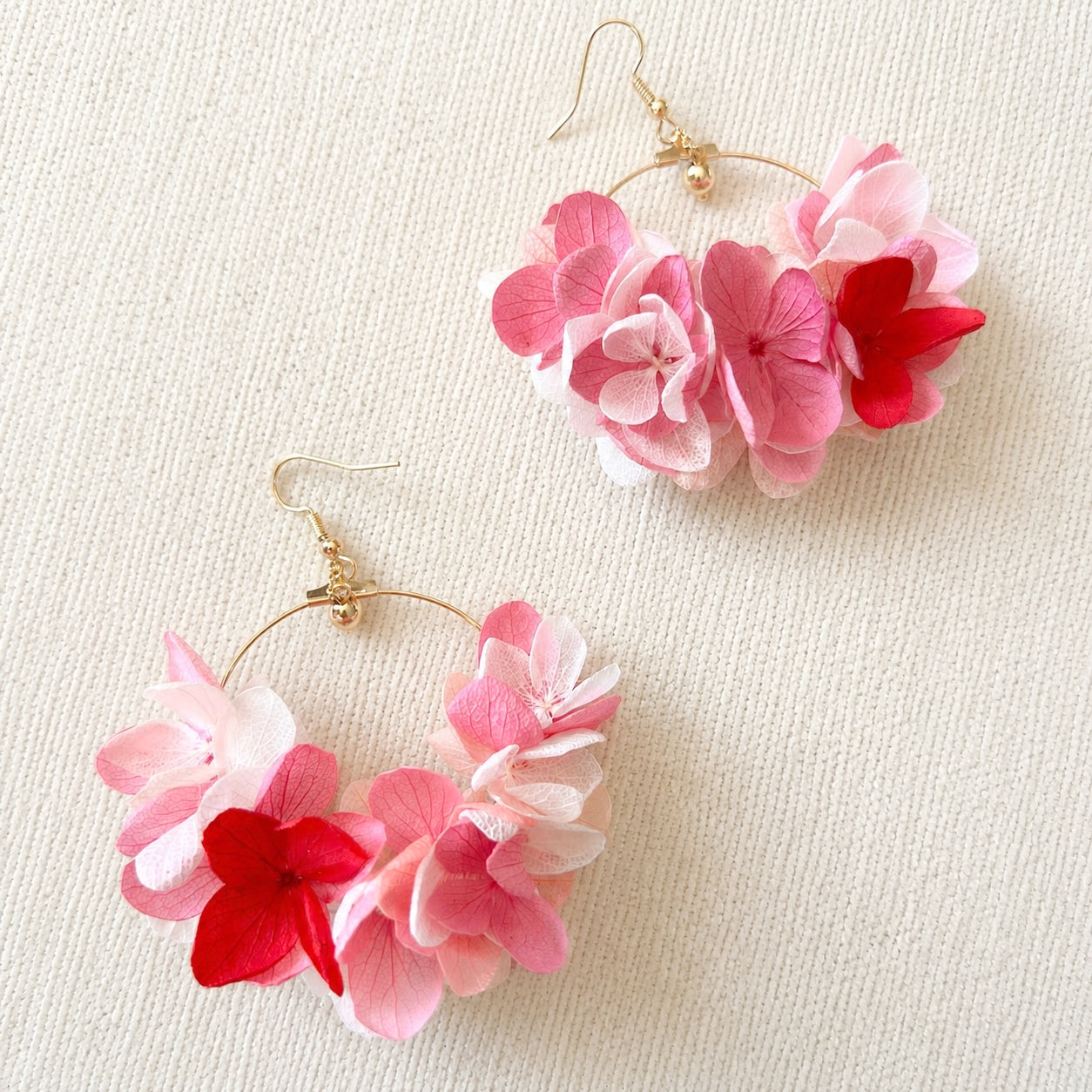 Boucles d'oreilles Rosée en hortensias stabilisés roses sur fond en lin
