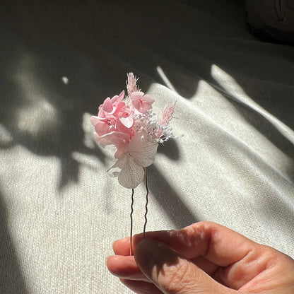 Épingles en fleurs stabilisées rose poudré et blanc présentées à la lumière naturelle
