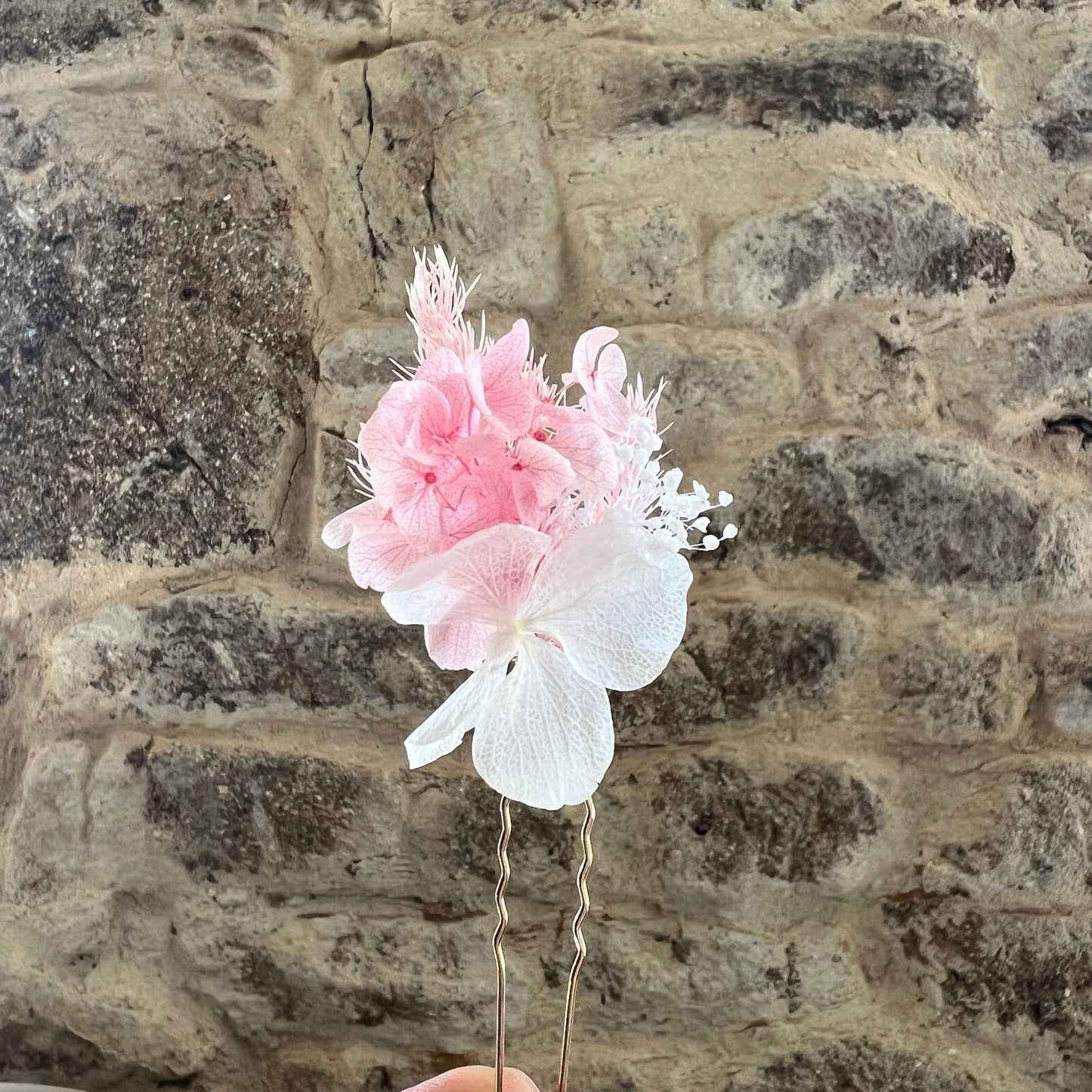 Épingles en fleurs stabilisées rose poudré et blanc présentées à la lumière naturelle