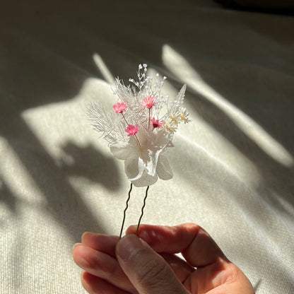 Épingles en fleurs stabilisées rose poudré et blanc présentées à la lumière naturelle