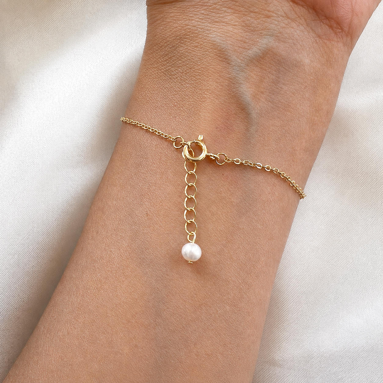 Bracelet fin Cléa avec perle d’eau douce pendante porté au poignet