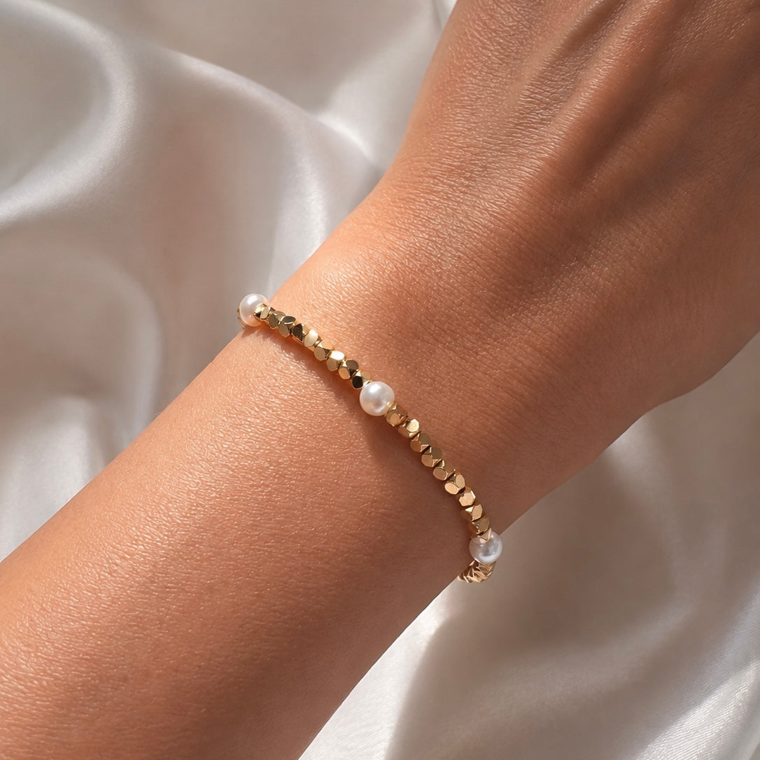 Bracelet Cléa en perles dorées et perles d’eau douce porté au poignet