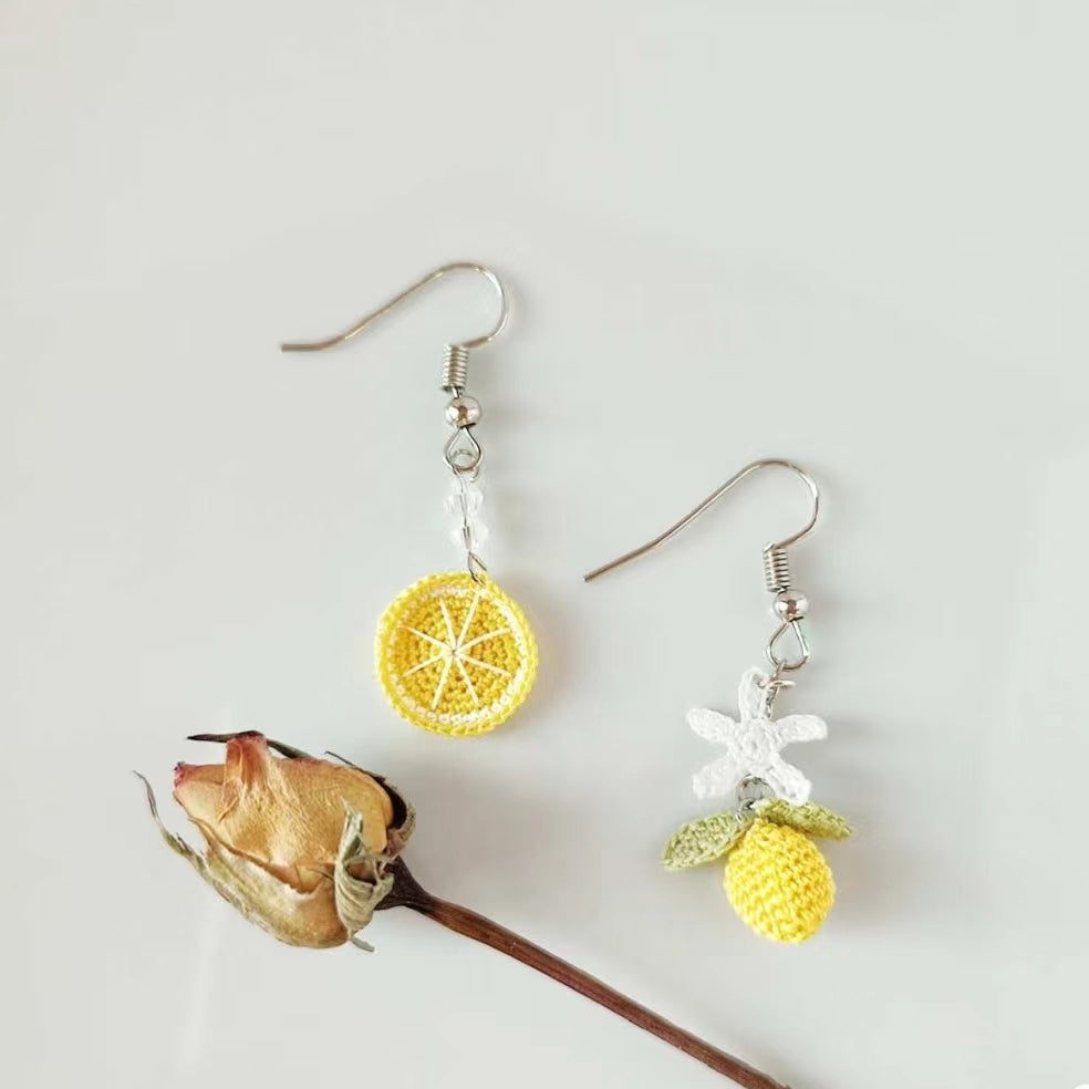 Image de boucles d'oreilles en crochet fait main, asymétriques avec un design de rondelle de citron et de fleur de citronnier, parfaites pour un look frais et estival