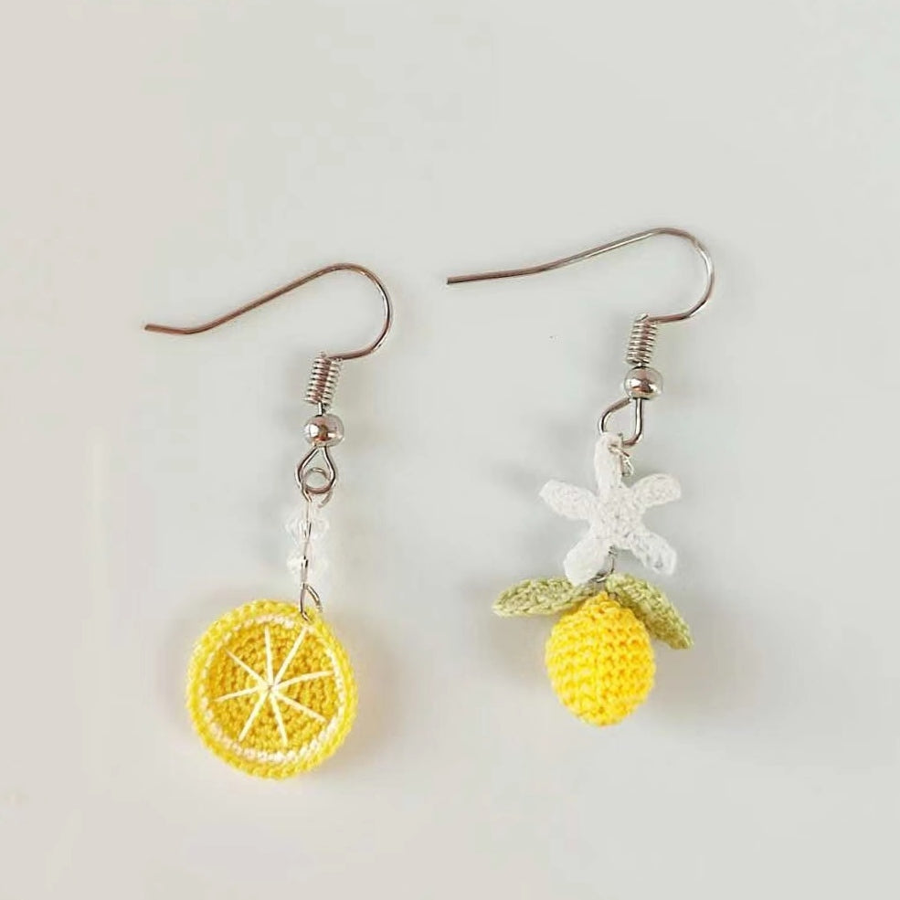 Image de boucles d'oreilles en crochet fait main, asymétriques avec un design de rondelle de citron et de fleur de citronnier, parfaites pour un look frais et estival