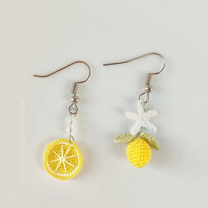 Image de boucles d'oreilles en crochet fait main, asymétriques avec un design de rondelle de citron et de fleur de citronnier, parfaites pour un look frais et estival