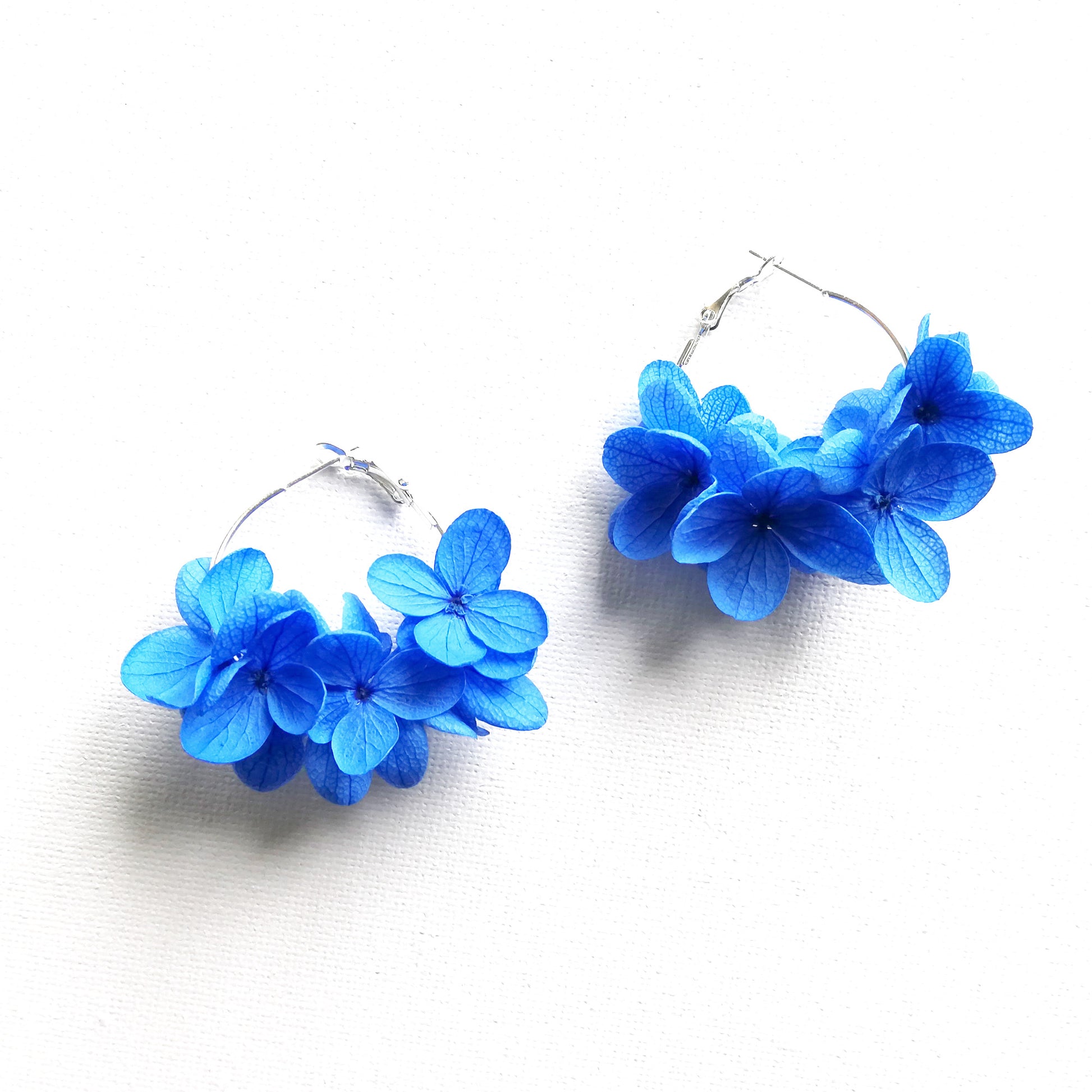 boucles d'oreilles créoles en fleurs bleues, fabriquées à la main avec des fleurs stabilisées, un accessoire unique pour un look frais et nature