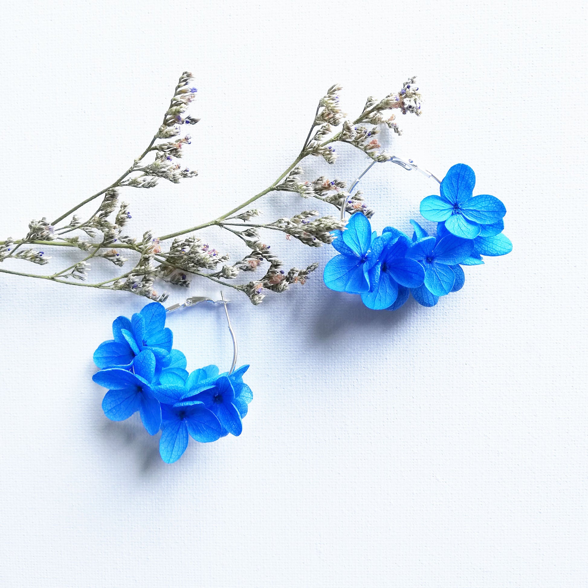 boucles d'oreilles créoles en fleurs bleues, fabriquées à la main avec des fleurs stabilisées, un accessoire unique pour un look frais et nature