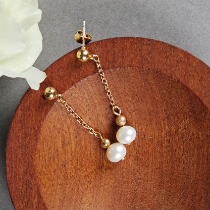 Boucles d'oreilles en perles élégantes, alliant chaîne dorée et perles d’eau douce pour un look sophistiqué.