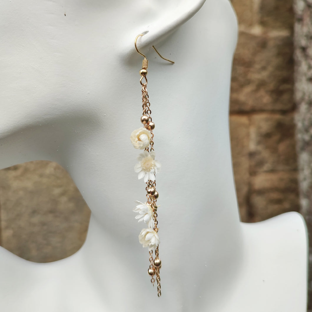 Boucles d’oreilles Élise en fleurs séchées, ornées de chaînes dorées et de perles délicates, disponibles en blanc