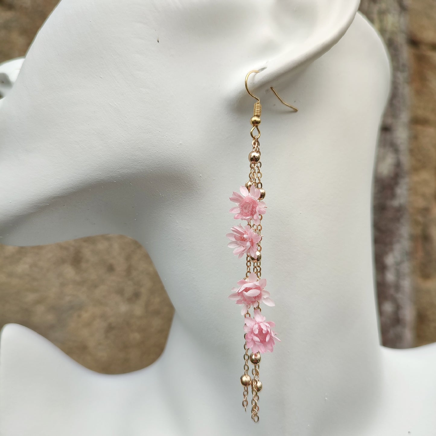 Élégantes boucles d’oreilles Élise avec fleurs séchées et chaînes dorées, inspirées de la nature pour un look unique.