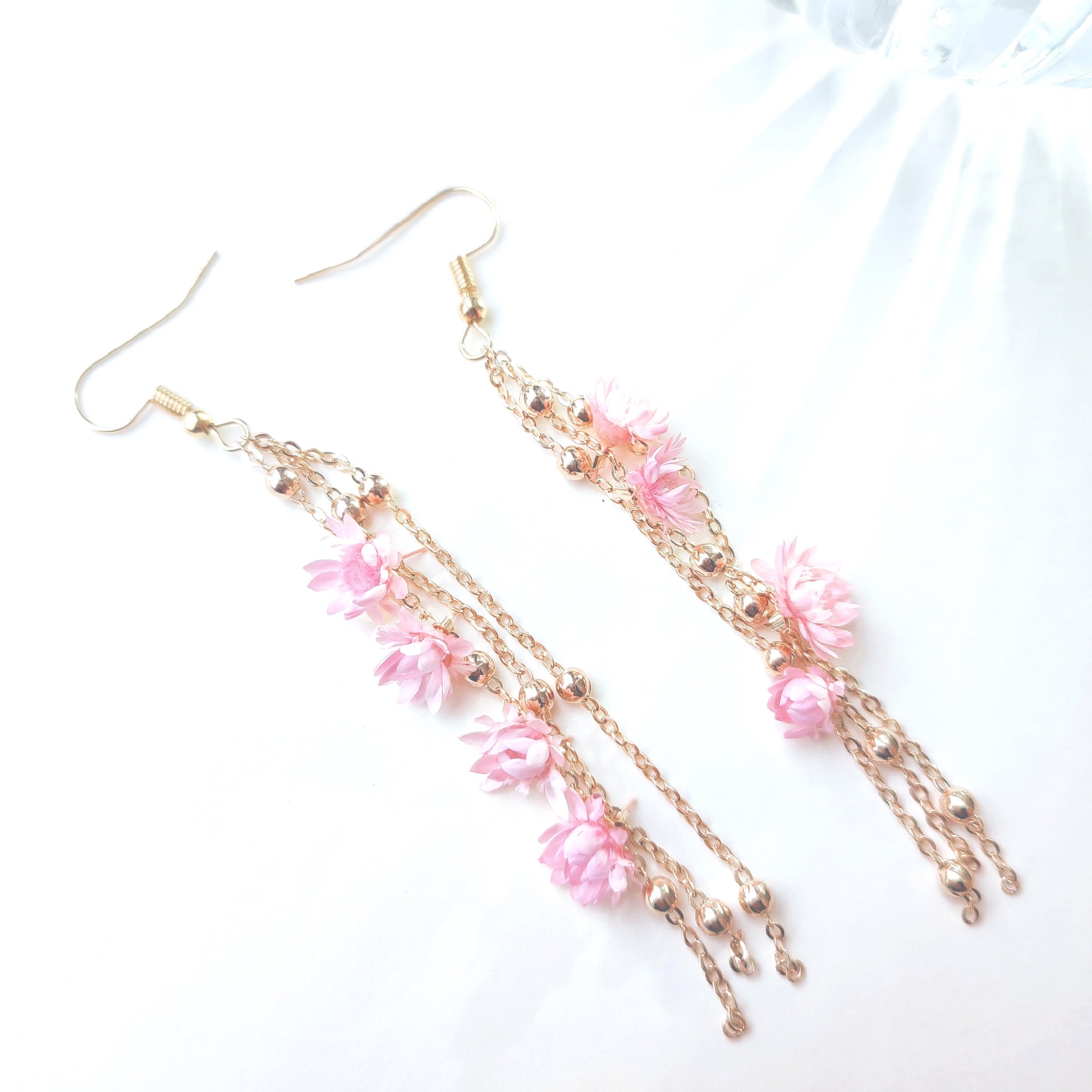 Boucles d’oreilles Élise en fleurs séchées, ornées de chaînes dorées et de perles délicates, disponibles en rose