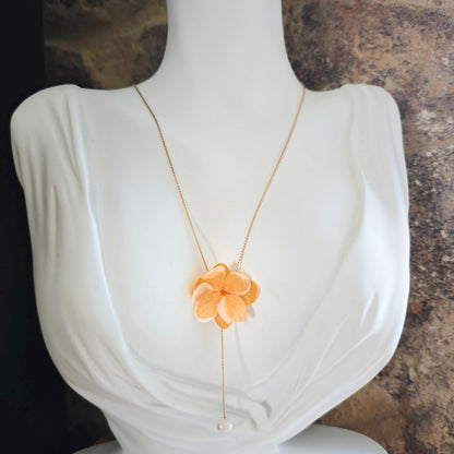 Collier artisanal avec fleur en tissu et perle nacrée, accessoire élégant pour cérémonie ou mariée.