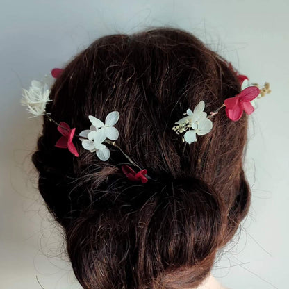 Détail de la couronne en fleurs stabilisées montrant les hortensias fuchsia et blancs, tressés dans des cheveux bruns.