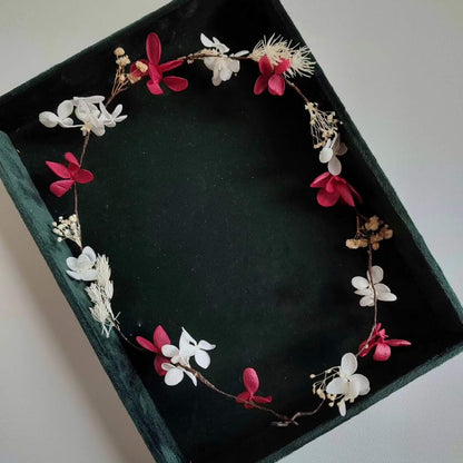 Couronne en fleurs éternelles composée d'hortensias fuchsia et blancs, disposée dans un écrin noir.