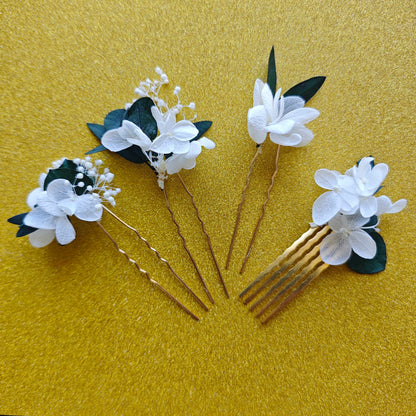 Accessoires de cheveux Sylvine en fleurs séchées blanches et feuillage vert, présentés à plat.
