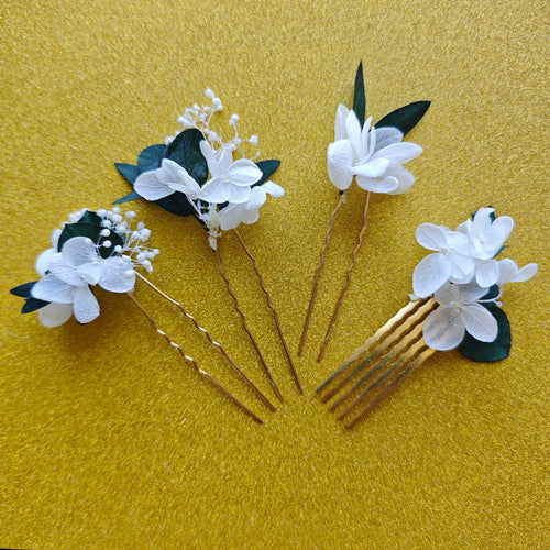 Accessoires de cheveux Sylvine en fleurs séchées blanches et feuillage vert, présentés à plat.