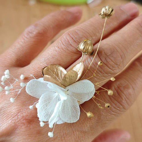  la bague Alcina, un bijou floral fait main avec fleurs séchées blanches, champagne et dorées. Idéale pour mariage, cérémonie, tenue blanch