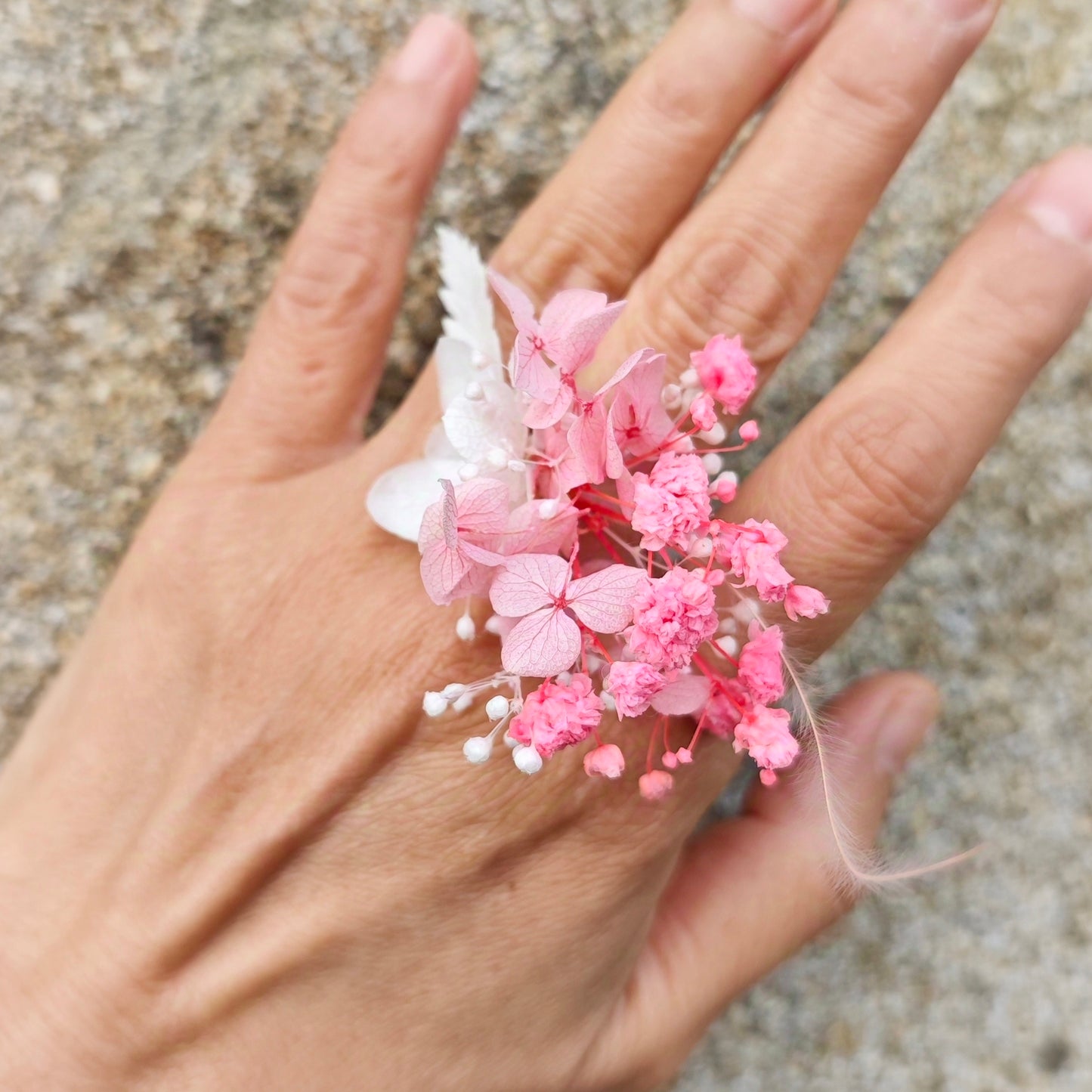 Détail de la bague en fleurs éternelles rose et blanche, élégante et romantique