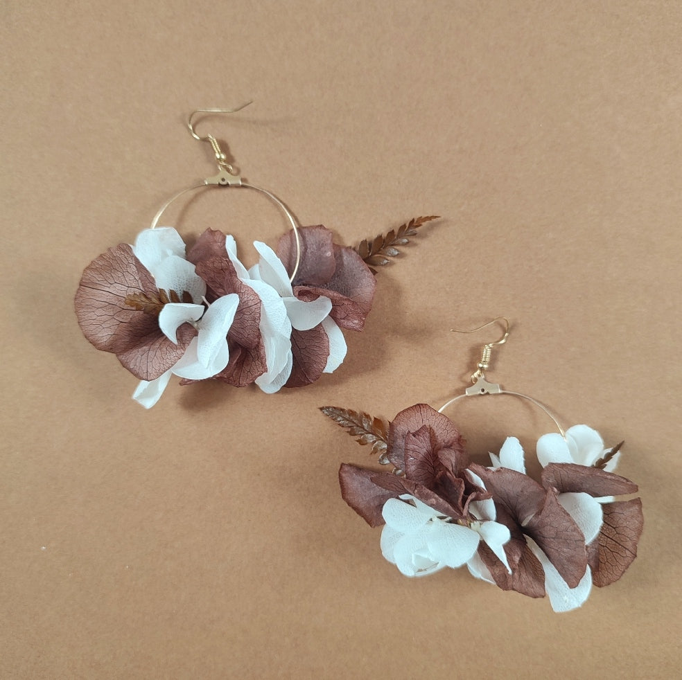 Détails de boucle d'oreille Ambre, combinaison de fleurs blanches et brunes.
