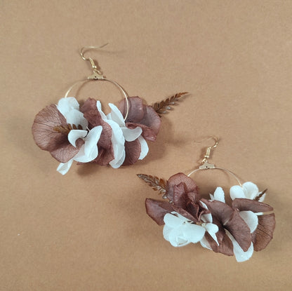 Détails de boucle d'oreille Ambre, combinaison de fleurs blanches et brunes.