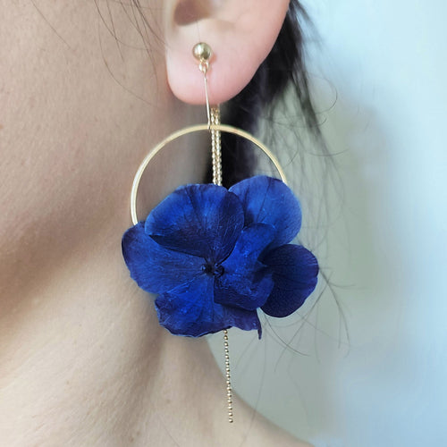 Boucles d'oreilles en fleurs éternelles bleues avec monture dorée élégante, style raffiné et délicat.