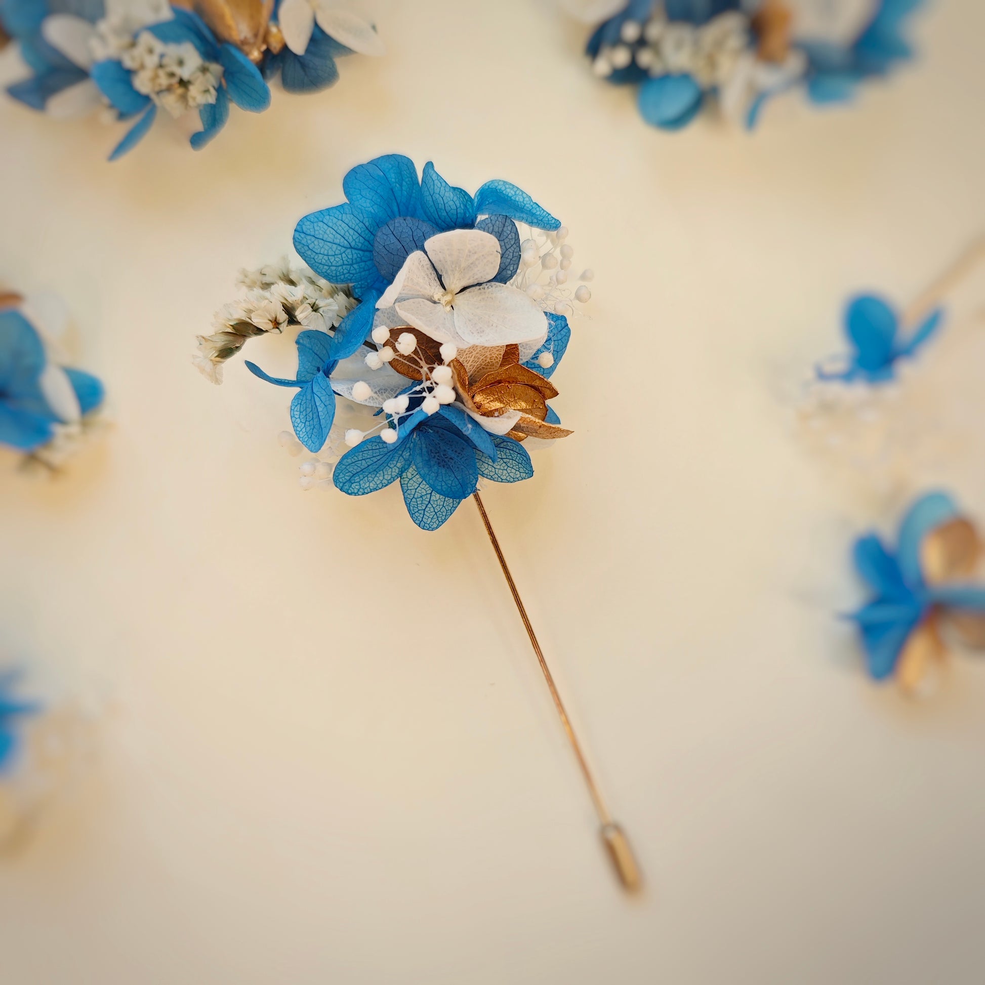 Boutonnière en fleurs séchées bleues, blanches et dorées de la collection Léonie