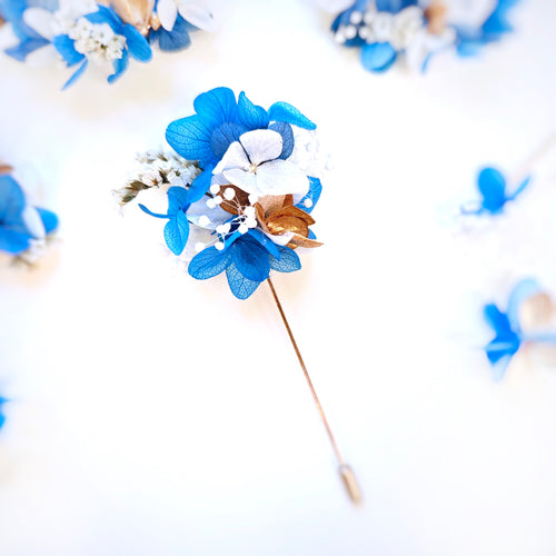 Boutonnière en fleurs séchées bleues, blanches et dorées de la collection Léonie