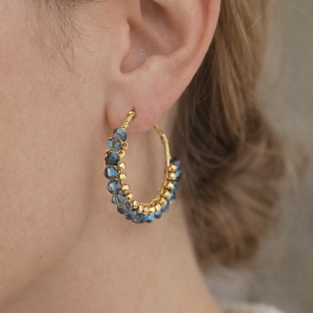 Créoles artisanales en perles bleues portées à l’oreille